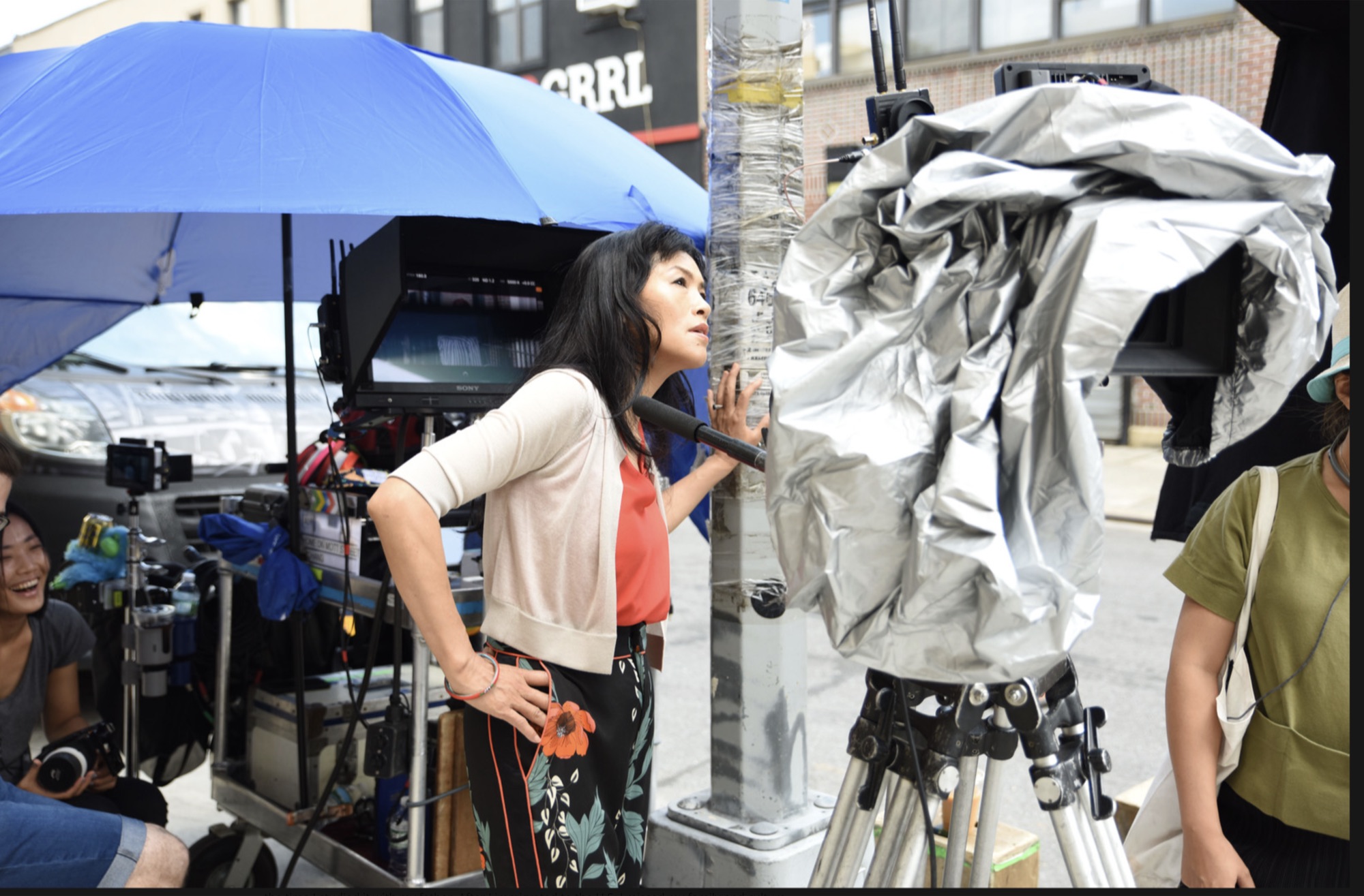 Grace Chang on a street film set under a blue canopy
